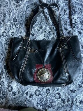 Black Shoulder Tote with Red Accent and Decorative Medallion